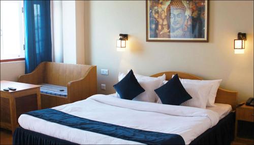 a hotel room with a large bed with blue and white pillows at Hotel Sodizang Retreat in Pelling