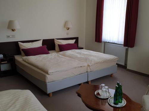 ein Schlafzimmer mit einem Bett und einem Tisch mit Flaschen darauf in der Unterkunft Hotel Bürgerhof Wetzlar in Wetzlar