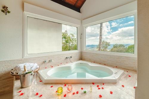 La salle de bains est pourvue d'une baignoire et d'une fenêtre. dans l'établissement Pousada Pedras e Sonhos, à Monte Verde