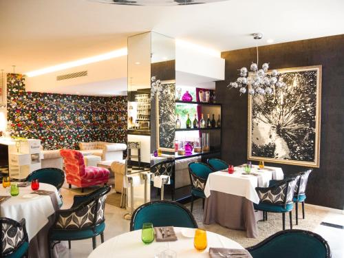 un restaurante con mesas y sillas blancas y una gran pintura en la pared en Aparthotel Monarque Sultán, en Marbella