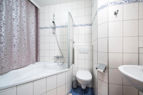 ein Badezimmer mit einer Badewanne, einem WC und einem Waschbecken in der Unterkunft Gasthof - Pension Ödsteinblick in Johnsbach