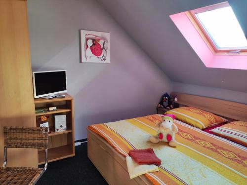 a bedroom with a bed with a teddy bear sitting on it at Penzion u Krtka in Kraslice