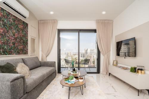 ein Wohnzimmer mit einem Sofa und einem großen Fenster in der Unterkunft HolySuite Even Israel in Jerusalem