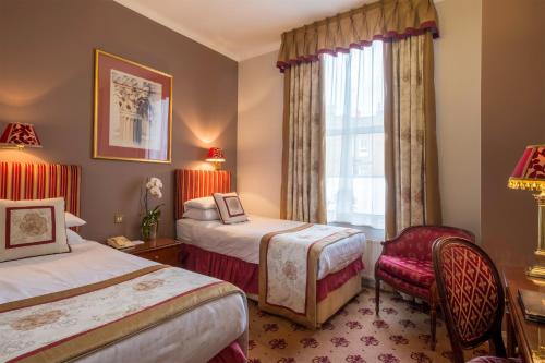 a hotel room with two beds and a window at London Lodge Hotel in London