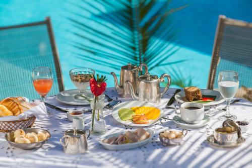 uma mesa com uma toalha de mesa branca com alimentos e bebidas em Pedra da Laguna Boutique Hotel SPA em Búzios