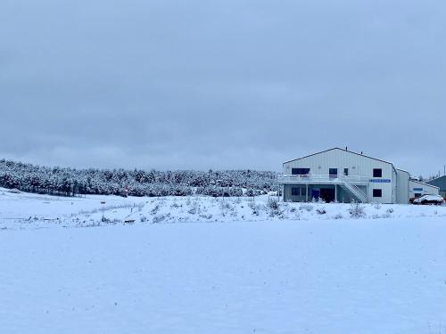un champ enneigé avec une maison en arrière-plan dans l'établissement Ecole de pilotage ULM LOZERE, à Mende
