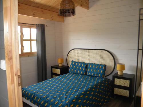 a bedroom with a bed with blue sheets and a window at Gîte et Chambres d'hôtes du Domaine du Val Bruant in Arc-en-Barrois