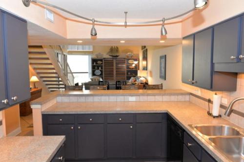 uma grande cozinha com armários azuis e uma escadaria em The Mainsail Resort em Destin