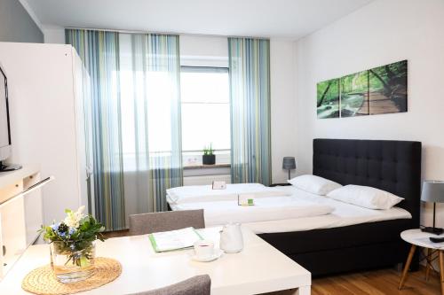 a hotel room with a bed and a desk and a room at Gästehaus zur Linde in Ingolstadt
