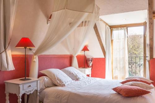 a bedroom with a white bed with a window at La Vigne du Pont in Vieux-Château