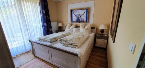 um quarto com uma cama com lençóis brancos e uma janela em Chalet Alpenblick Inzell em Inzell