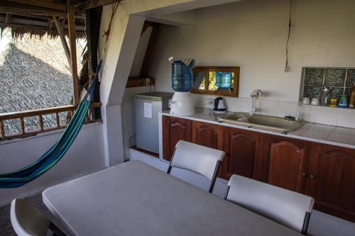 a kitchen with a table and chairs and a sink at AABANA Beach & Watersport Resort in Malapascua Island
