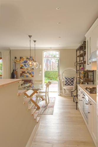 a kitchen with a table and a dining room at Charming Coastal Townhouse at The Majestic in Kalk Bay