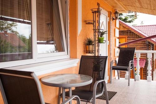 a porch with a table and chairs and a window at Villa Magnat in Berehove