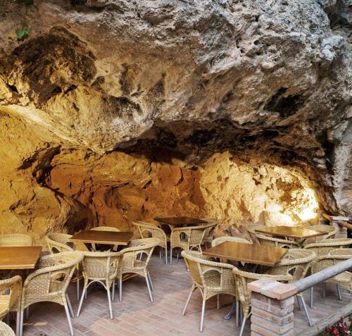 a restaurant with tables and chairs in a cave at Hotel Balneario de La Virgen in Jaraba