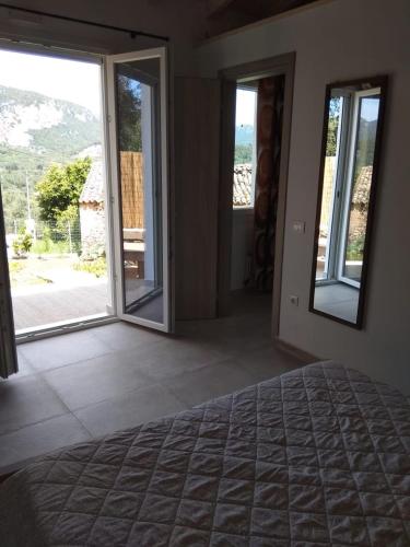 a bedroom with a bed and sliding glass doors at Oliveways in Liapades