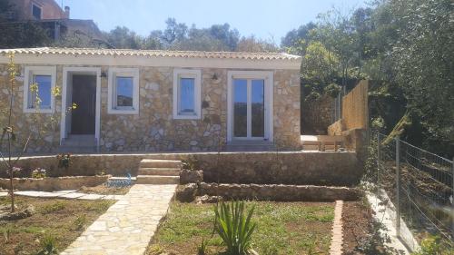 a stone house with a stone staircase in front of it at Oliveways in Liapades
