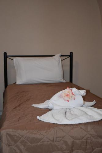 a bed with a white towel and a rose on it at Mantilaria in Fira