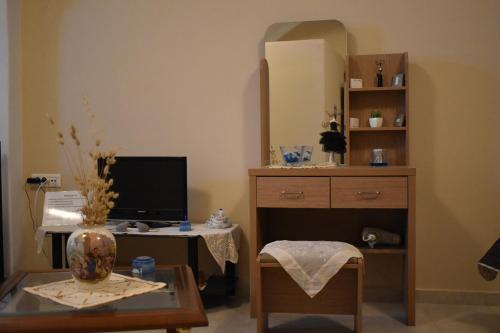 a room with a desk with a computer and a mirror at Mantilaria in Fira