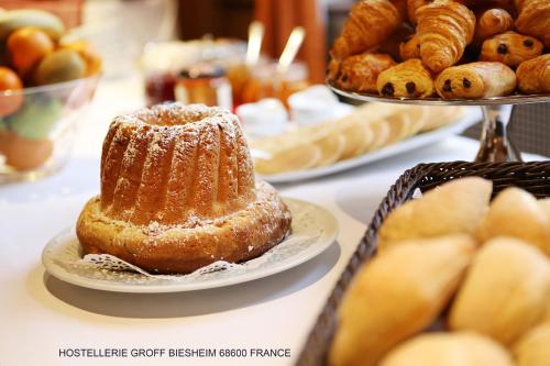 a table topped with plates of bread and pastries at Aux Deux Clefs - Hôtel Restaurant Groff in Biesheim