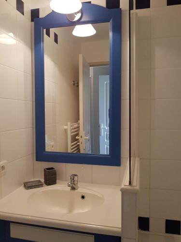 La salle de bains est pourvue d'un lavabo et d'un miroir bleu. dans l'établissement Cap Marine 8, au Guilvinec