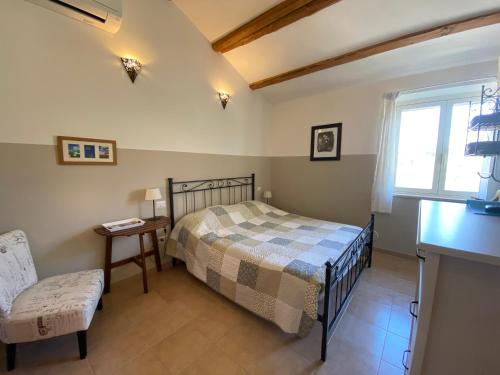 a bedroom with a bed and a chair and a window at Casa Cologna B&B in Roseto degli Abruzzi