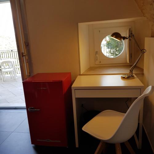a desk with a lamp and a chair next to a window at Bed and Breakfast Terra del Sole Ibla in Ragusa