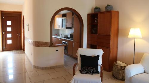 salon z białym krzesłem i kuchnią w obiekcie Soada w mieście Cappelle sul Tavo