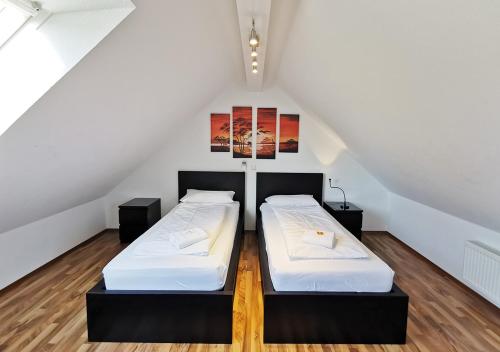 two beds in a room with a attic at duplex apartment - city centre - airconditioned - netflix - 2 balconies in Heidelberg