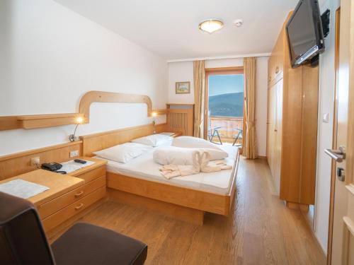 マランツァにあるHotel Oberlechnerのベッドルーム1室(鏡付きのベッド1台、窓付)