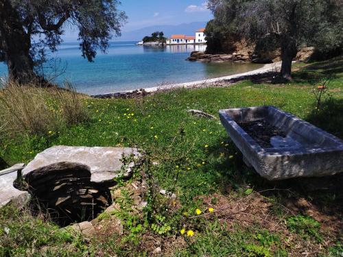 a blue tub sitting in the grass near the water at Athina-Milina in Milína