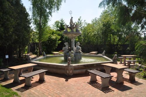 fontanna w parku ze stołami piknikowymi i ławkami w obiekcie Zajazd pod Lwem w mieście Trzebnica