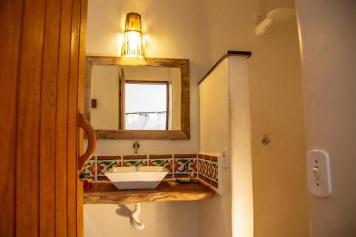 a bathroom with a sink and a mirror at Pousada Le Refuge in Trancoso