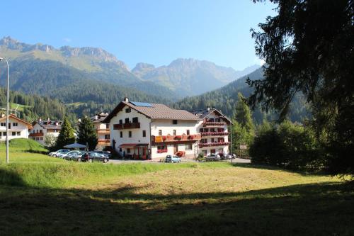 ファルカーデにあるHotel Cime d'Autaの山を背景にした一群の建物