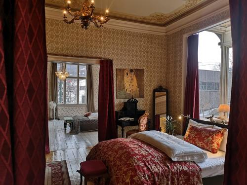 een slaapkamer met een bed en een kroonluchter bij Villa Karine in Bergen