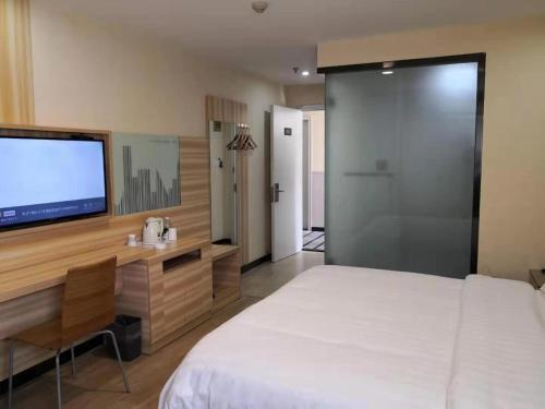 a bedroom with a large bed and a flat screen tv at 7Days Inn Changsha Yinpenling ridge AUX Plaza in Changsha