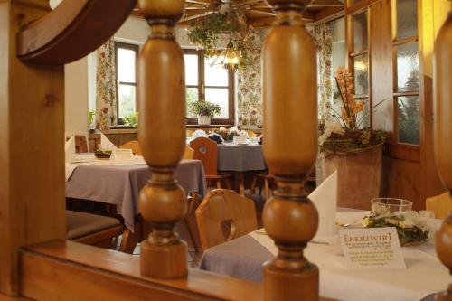 a dining room with tables and chairs and windows at Hotel - Restaurant Eberlwirt in Bruckberg
