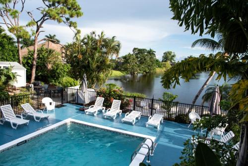 a swimming pool with chairs and a river at Marco Island Lakeside Inn in Marco Island