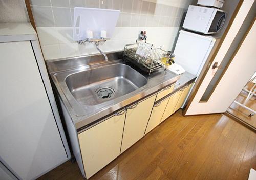 uma cozinha com um lavatório de aço inoxidável e um frigorífico em Kyoto - Apartment / Vacation STAY 7424 em Quioto