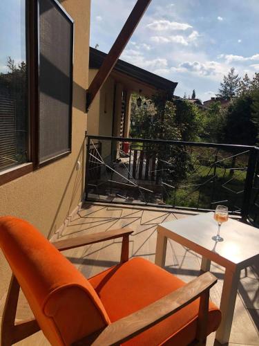 an orange chair and a table on a balcony at Karali Apartments in Lagadin