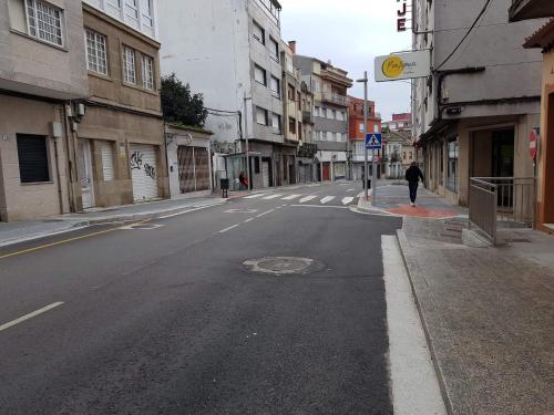 an empty city street with a person walking down the street at Apatamento as xenetas in Marín