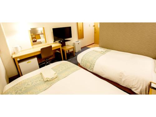 a hotel room with two beds and a desk at Hakata Floral Inn Nakasu / Vacation STAY 80214 in Fukuoka