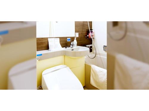 two pictures of a bathroom with a toilet and a sink at Hakata Floral Inn Nakasu / Vacation STAY 80214 in Fukuoka