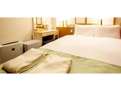 福岡市にあるHakata Floral Inn Nakasu / Vacation STAY 80216のベッドとデスクが備わるホテルルームです。