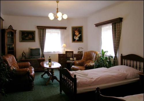 a bedroom with a bed and chairs and a table at Hotel Klor in Doudleby