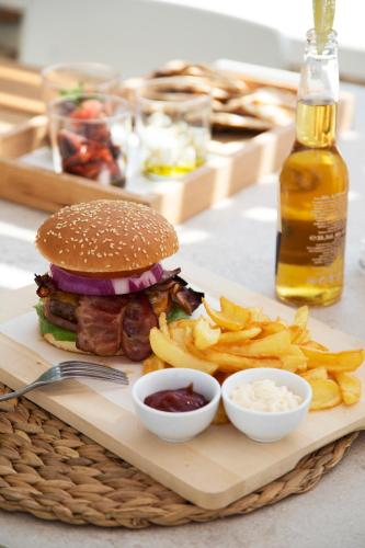 a tray with a sandwich and fries and a bottle of beer at Hide Out Suites in Mylopotas