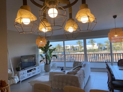 a living room with a couch and a tv at Almaza bay Beach Town Chalet in Marsa Matruh