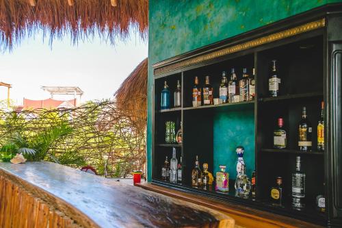 un bar con un montón de botellas en la pared en La Puerta Azul Beachfront - Adults Only en Holbox Island