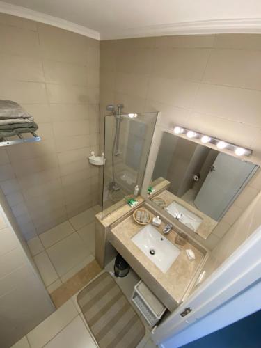 a bathroom with a sink and a shower and a mirror at Almaza bay Beach Town Chalet in Marsa Matruh