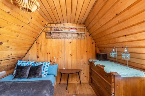 a room with two beds in a log cabin at Domek Rożnów 2 in Rożnów